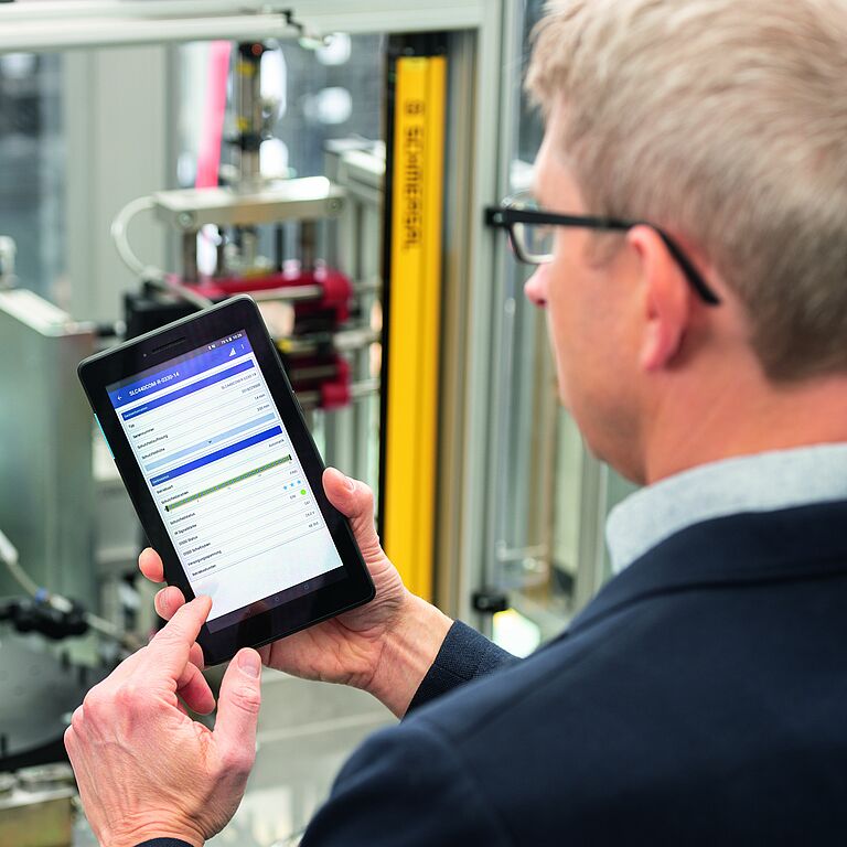 photo, man holding smartphone with SLC Assist App open